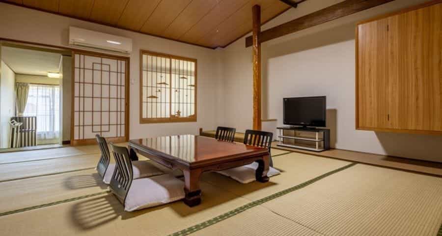 Sit down at the low table in a Ryokan Sawaki room